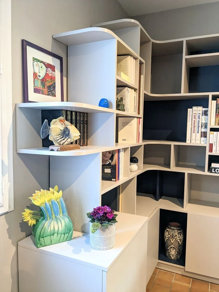Intérieur moderne avec bibliothèque modulaire en métal noir et bois, remplie de livres colorés