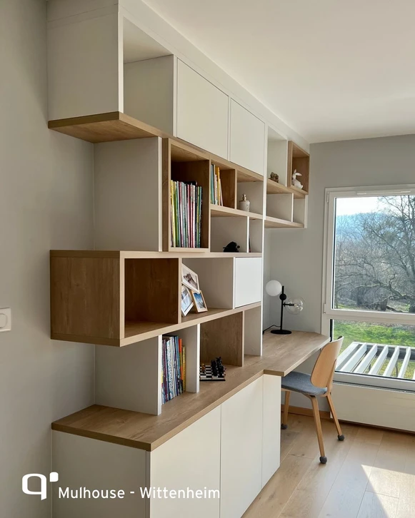 Intérieur d'atelier artisanal avec étagères en bois brut contenant une collection de livres anciens reliés cuir, carnets et albums photo vintage
