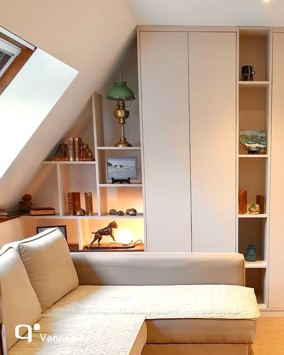 Chambre mansardée avec charpente apparente en bois naturel, poutres exposées et plafond cathédrale