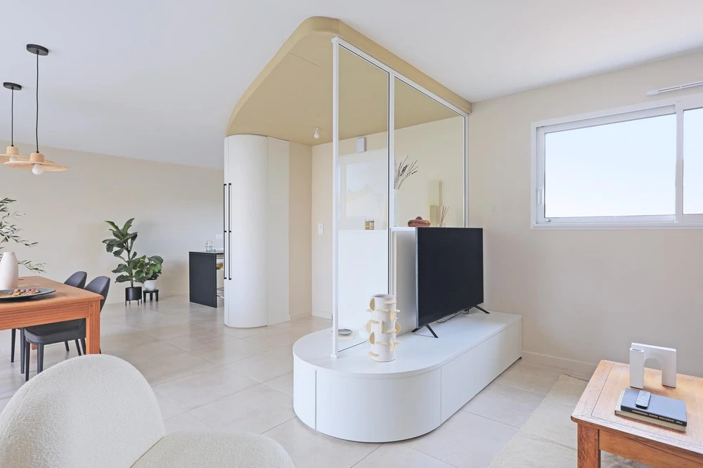 Salon moderne avec cheminée encastrée allumée intégrée dans meuble TV blanc et bois