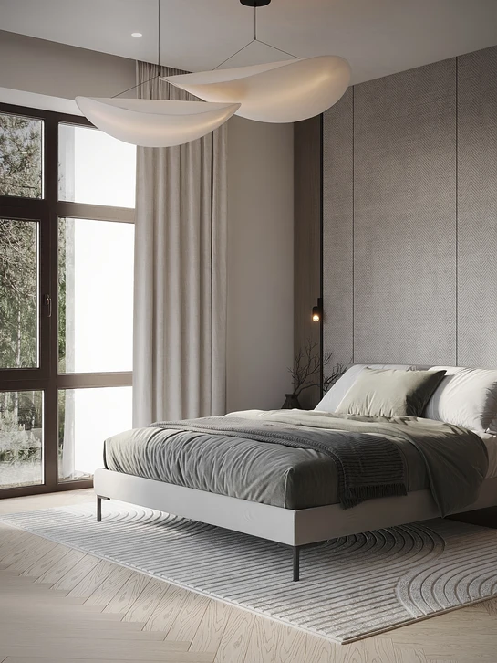 Chambre moderne avec lit double à tête de lit capitonnée grise, linge de lit rayé blanc et bleu, plaid tricoté beige