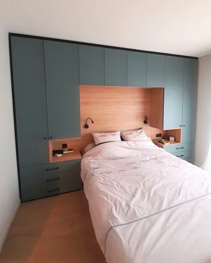 Chambre sous combles aménagée avec lit double en bois massif, tête de lit à lames horizontales, literie blanche et couverture anthracite